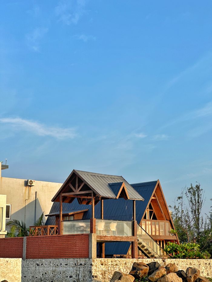 Mastering the First Impression: Your intriguing post title goes here Charming A-frame house with rustic design under a clear blue sky, perfect for vacation getaways.