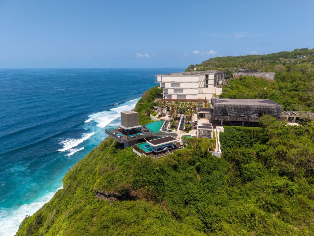 Aerial view of a luxurious cliffside resort with infinity pools in Bali, Indonesia.